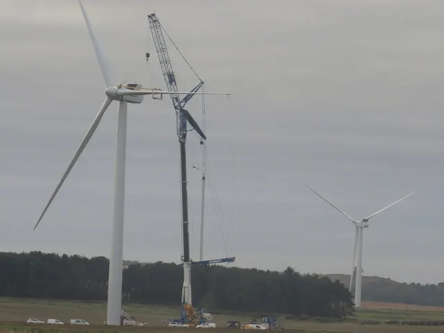 A crane beside a wind turbine during construction