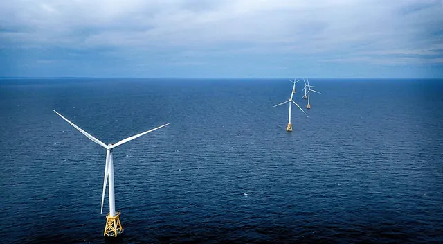 Offshore wind turbines in a deep blue sea, seen from the air