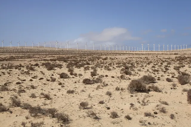 Wind turbines along the horizon of a stony desert plain