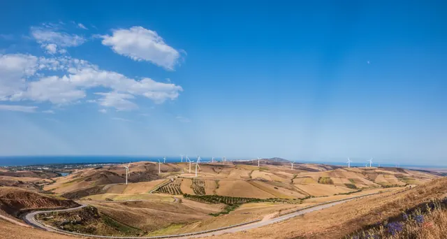 Wind turbines on golden hills above the coast at El Alia
