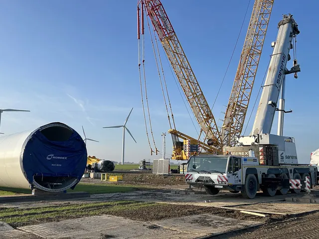 Cranes and a nacelle at a wind turbine construction site