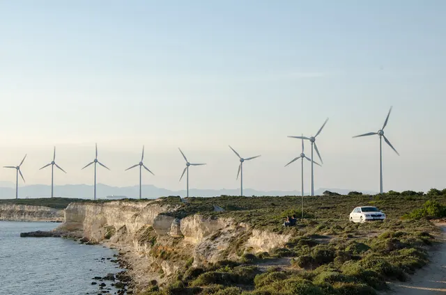 Wind turbines along a cliff edge above the sea