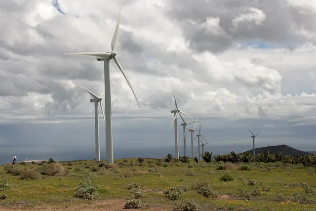 Wind turbines on volcanic ground under a cloudy sky
