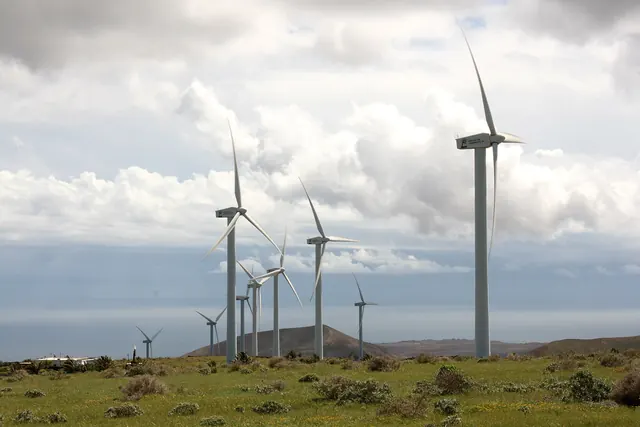 A row of wind turbines on a green volcanic plateau