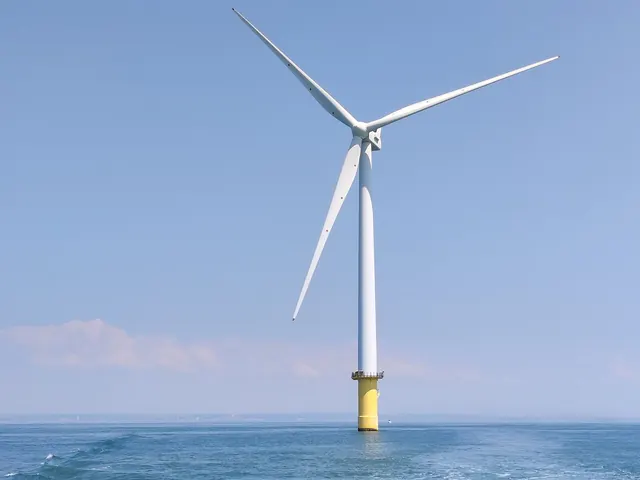 A single offshore wind turbine on a yellow foundation