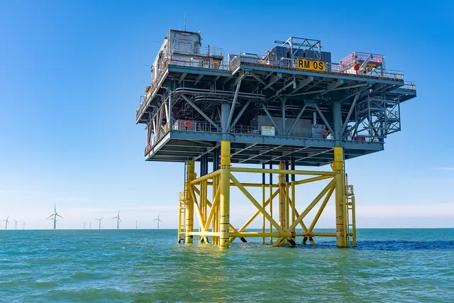 An offshore substation platform on yellow legs at sea