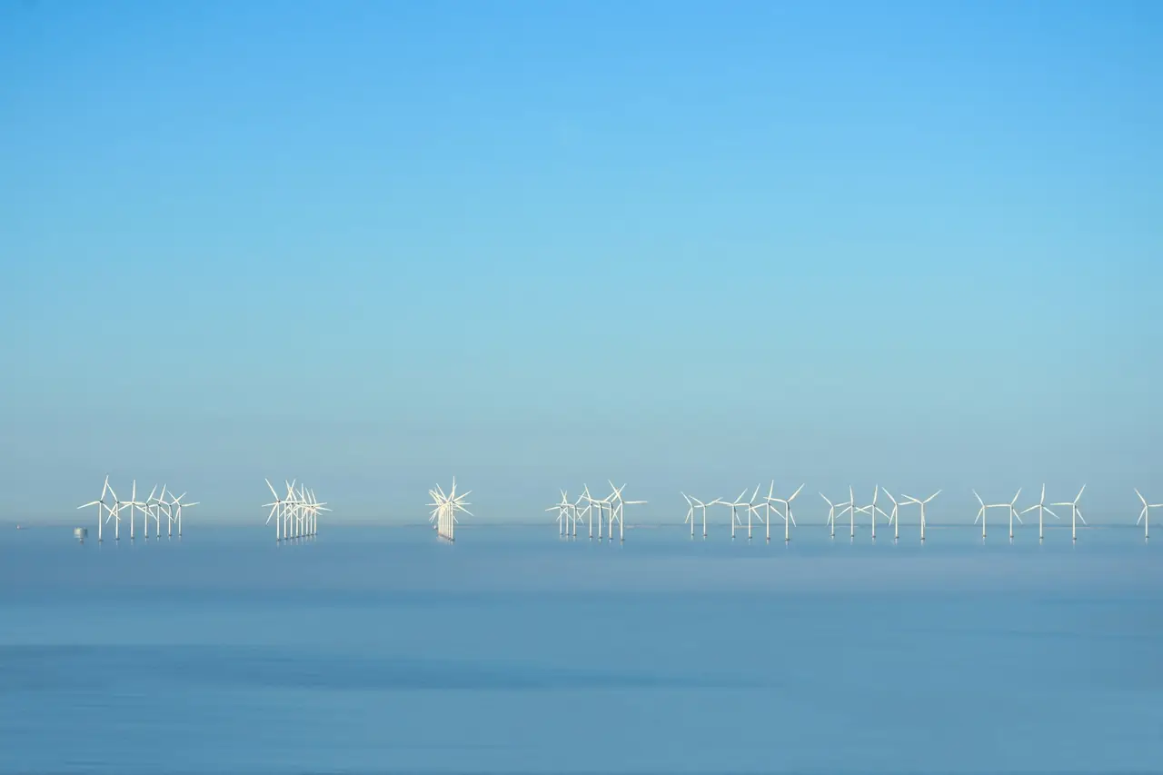 An offshore wind farm on a flat blue horizon